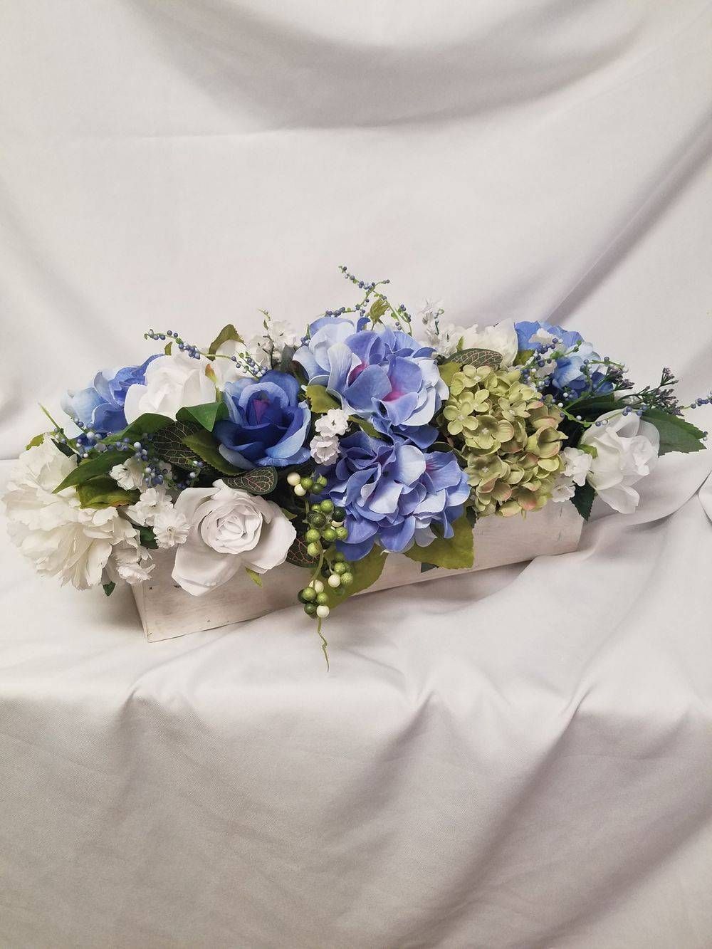 A vase filled with blue and white flowers is sitting on a table.