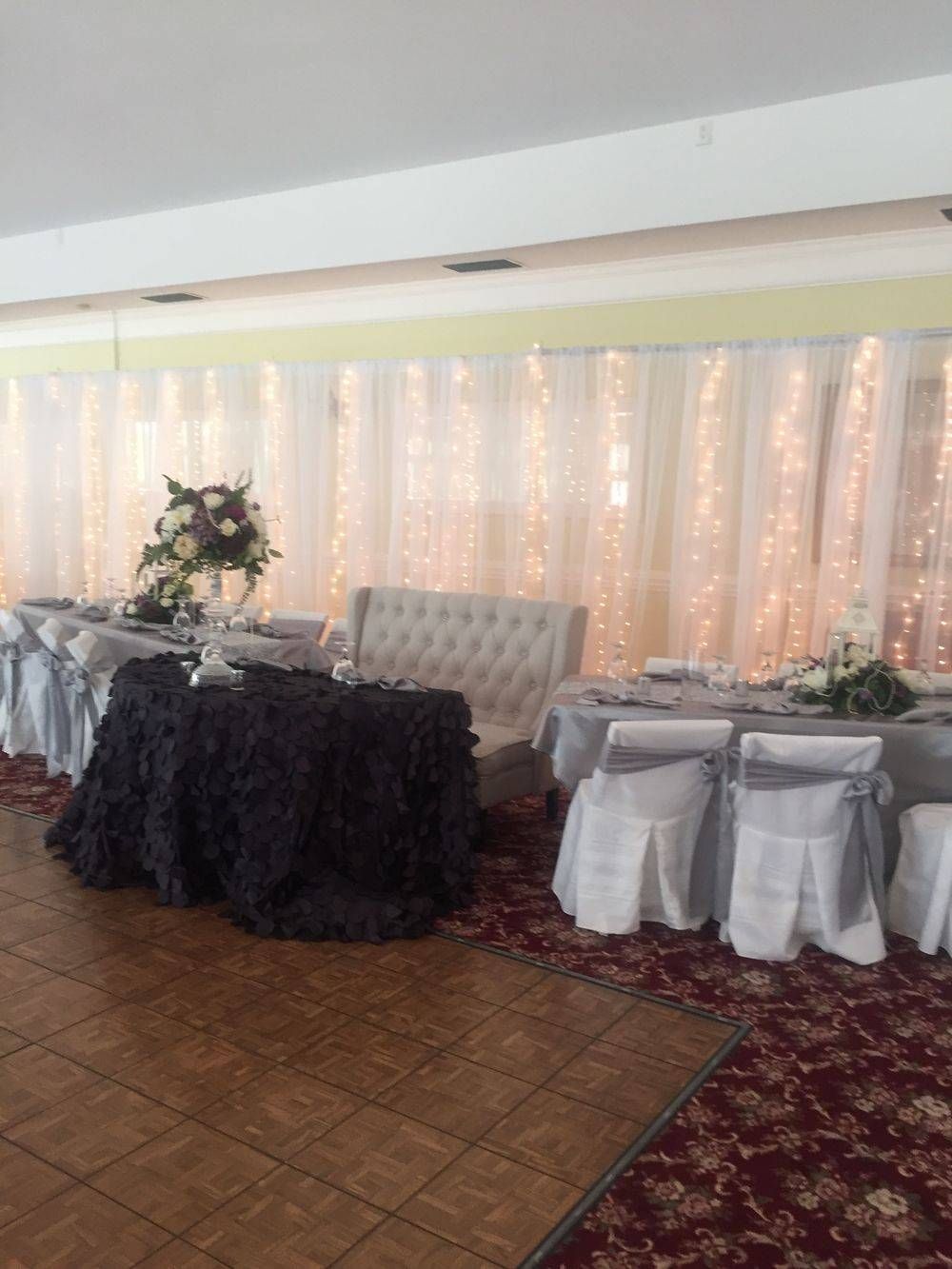 A room with tables and chairs set up for a wedding reception.