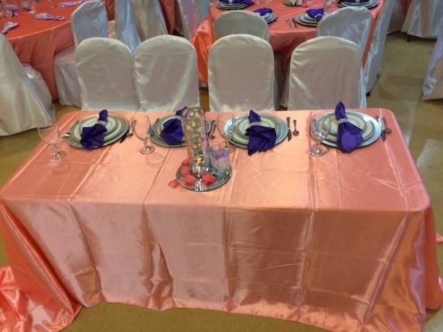 A table with plates and silverware on it and a pink table cloth