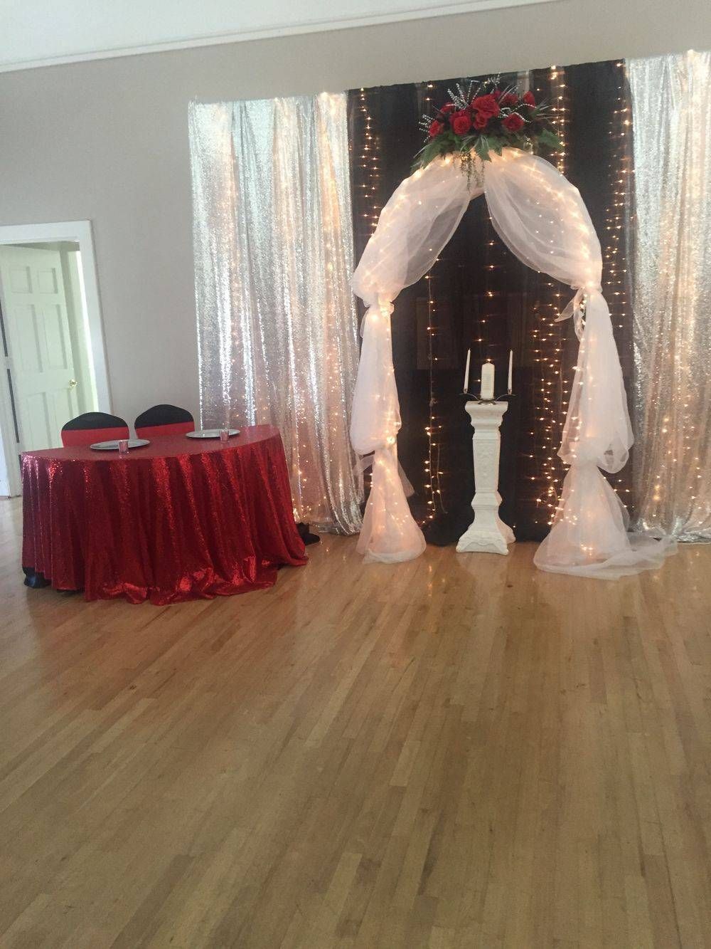 A room with a red tablecloth and a white arch.