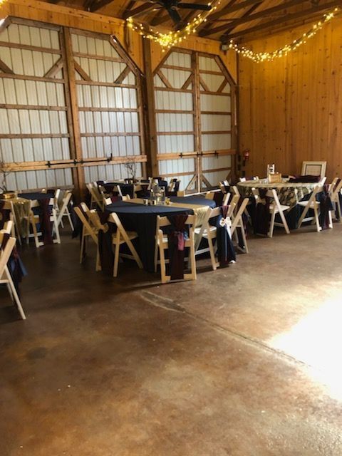 A large room with tables and chairs set up for a wedding reception.