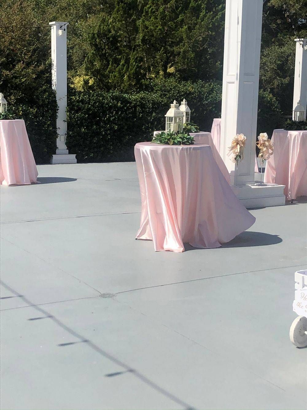 A patio with pink tables and white chairs