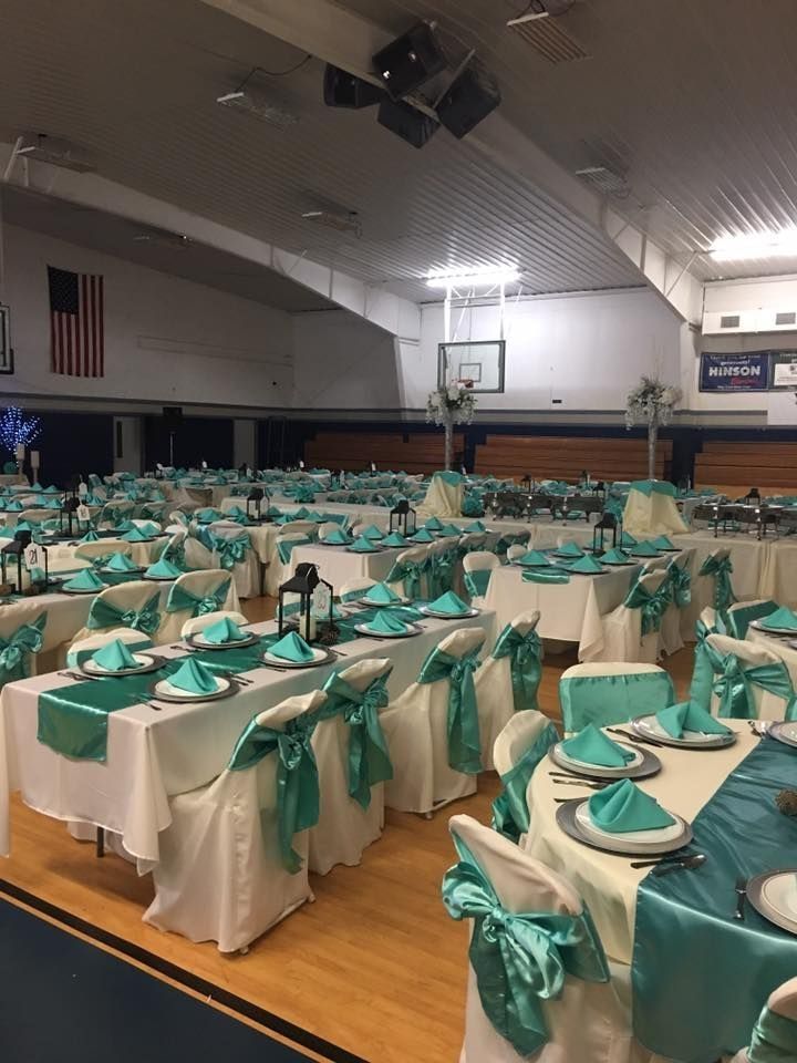 A large room with tables and chairs set up for a wedding reception.