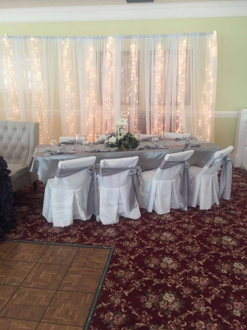 A room with a table and chairs set up for a wedding reception.
