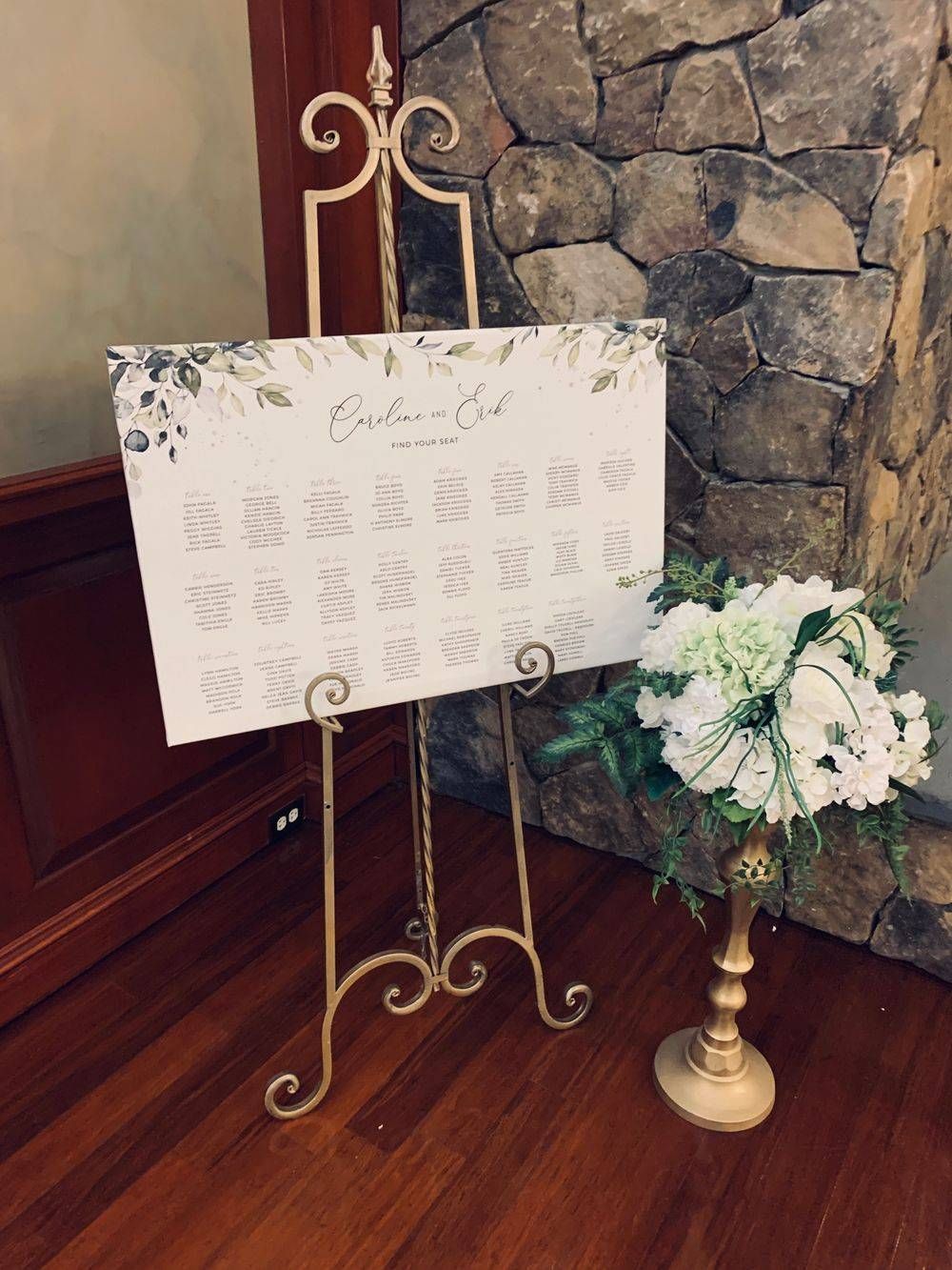 A sign on an easel next to a vase of flowers.