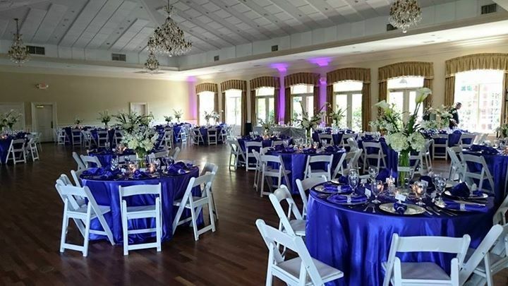 A large room with tables and chairs set up for a wedding reception.
