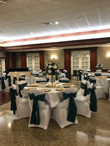 A large room with tables and chairs set up for a wedding reception.