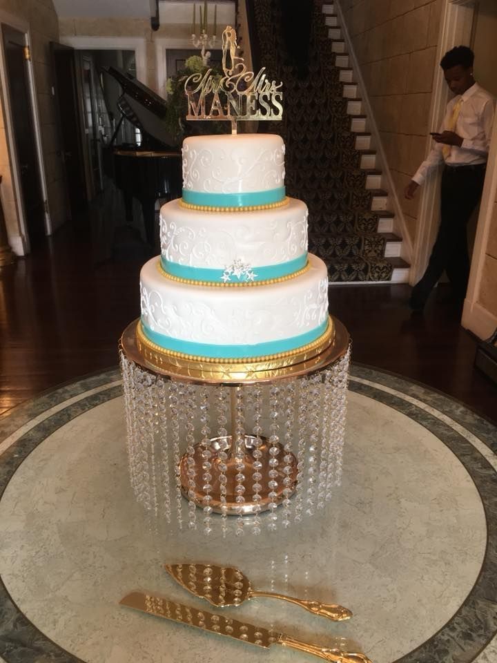 A wedding cake is sitting on top of a crystal cake stand.