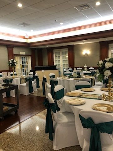 A large room with tables and chairs set up for a wedding reception.