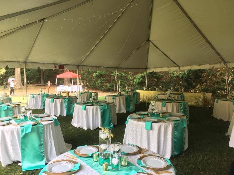 Tables and chairs are set up under a tent for a wedding reception.
