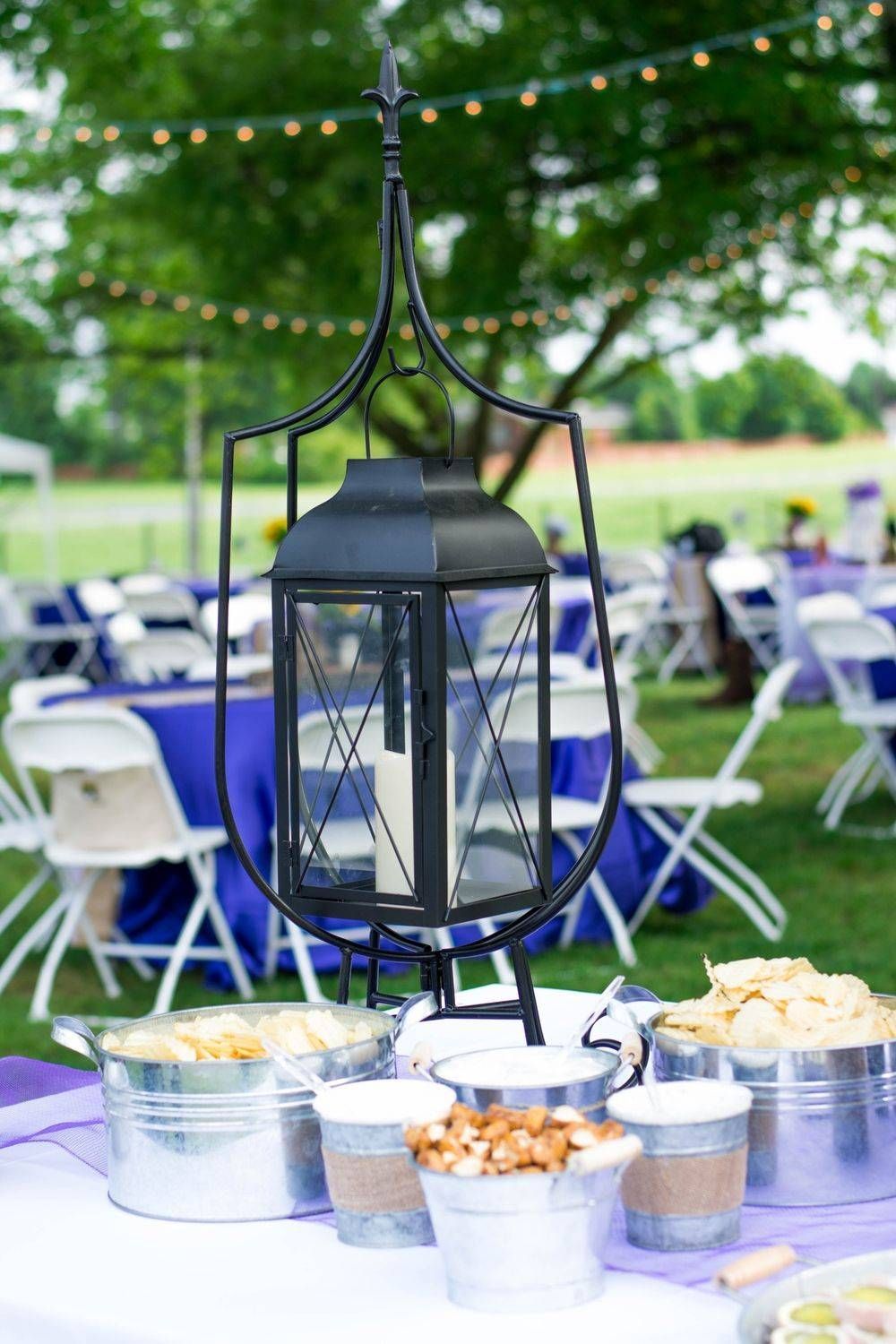 A black lantern is sitting on top of a table with buckets of food.