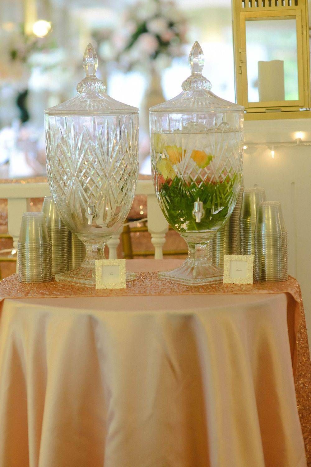 A table with a vase of flowers and cups on it.