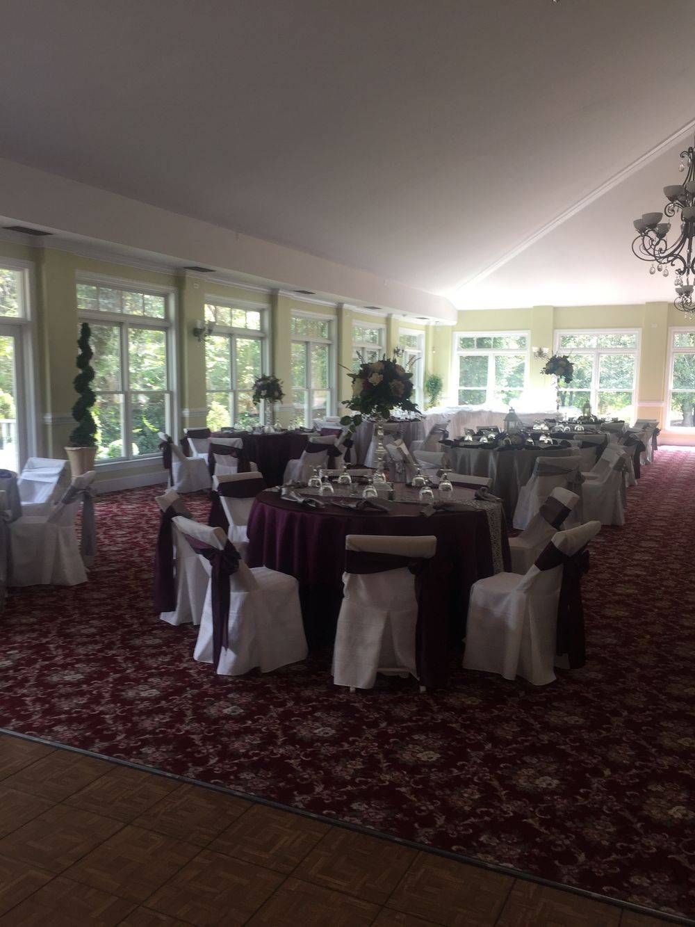 A large room with tables and chairs set up for a wedding reception.