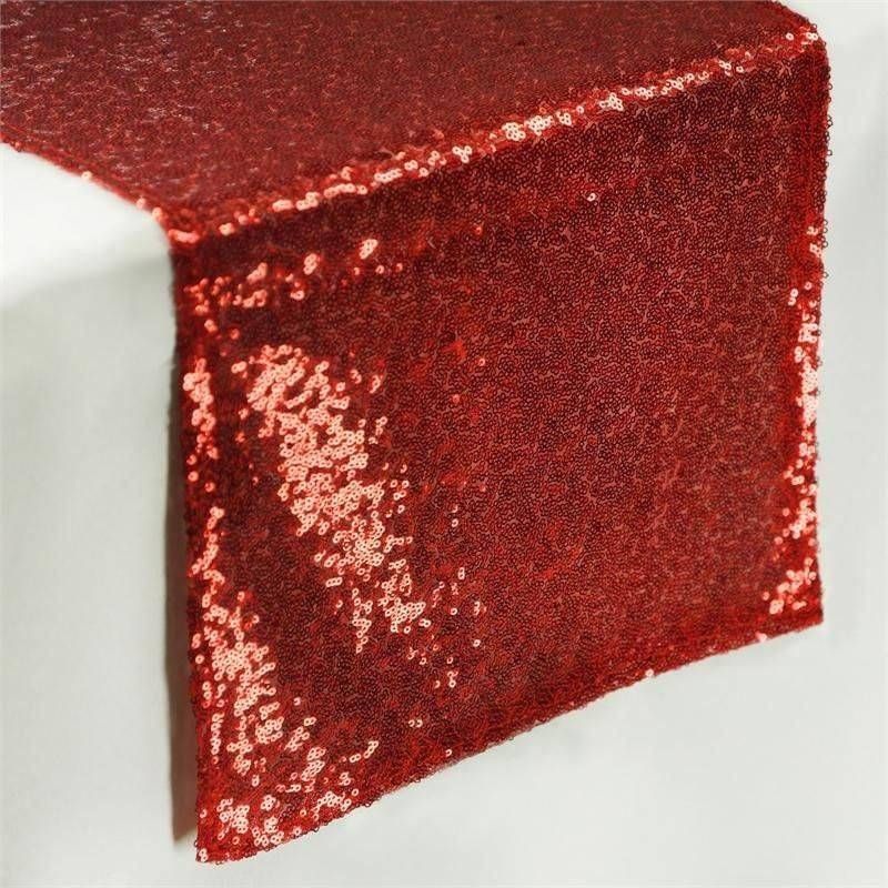 A red sequined table runner is on a white table