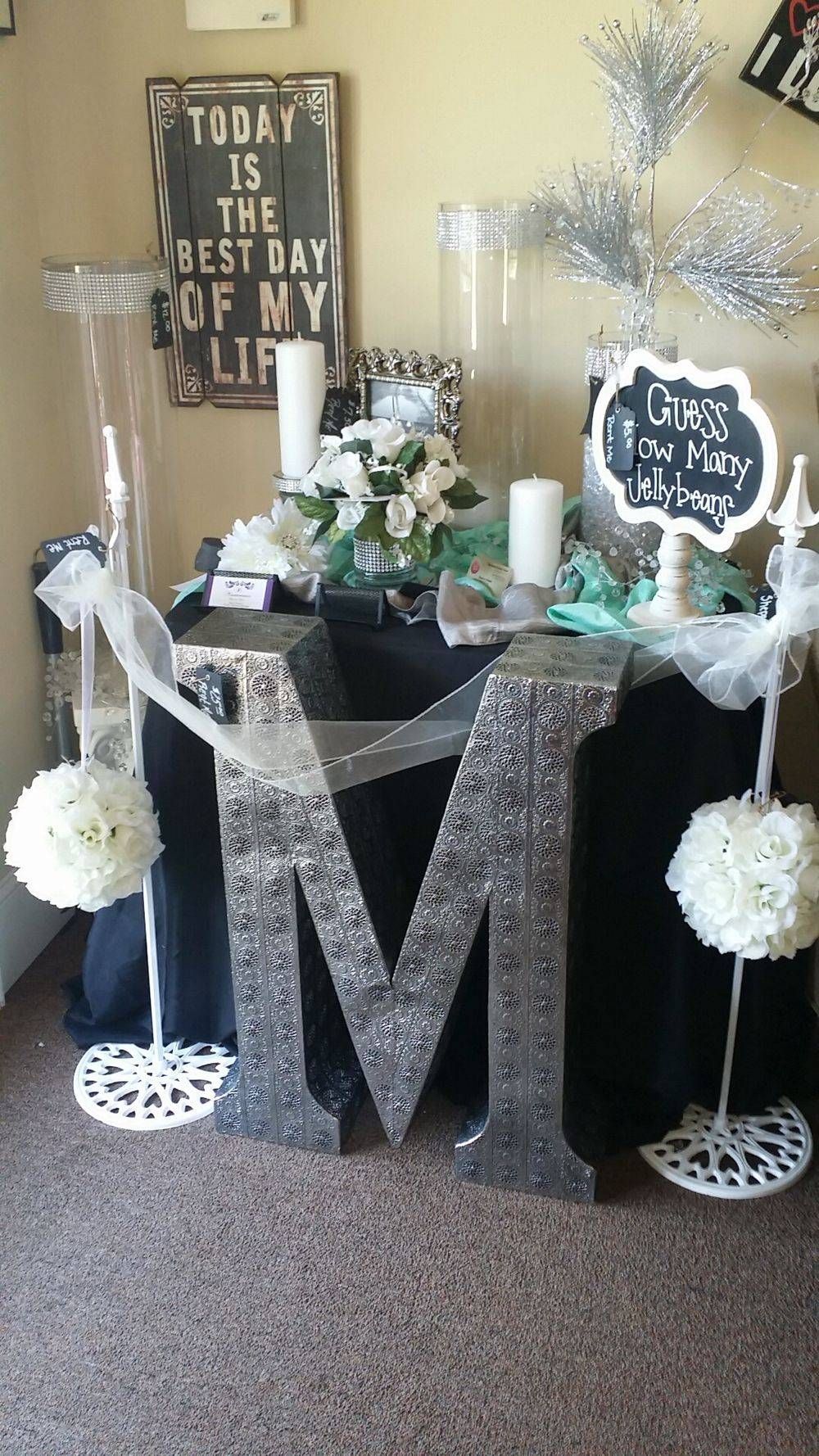 A large silver letter m is sitting on top of a table.