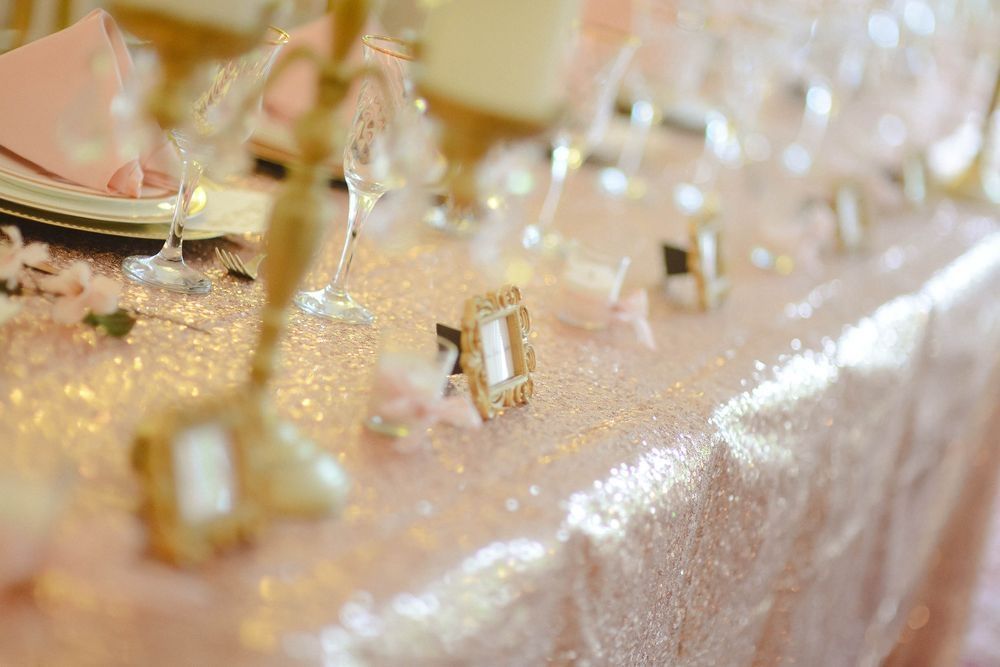 A table with plates , glasses , and place cards on it.