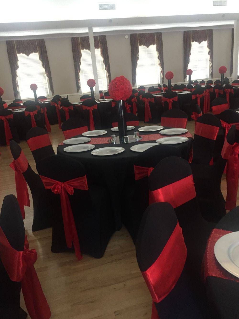 A large room with black tables and red chairs