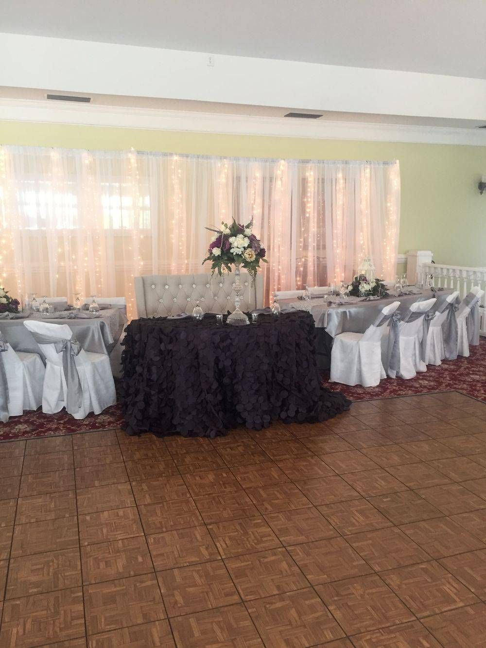 A large room with tables and chairs set up for a wedding reception.