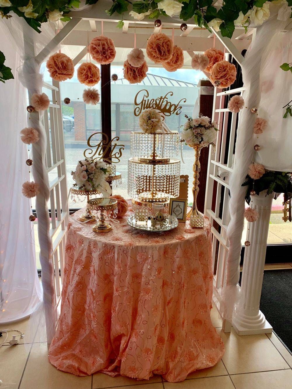 A table with a pink tablecloth and flowers on it.