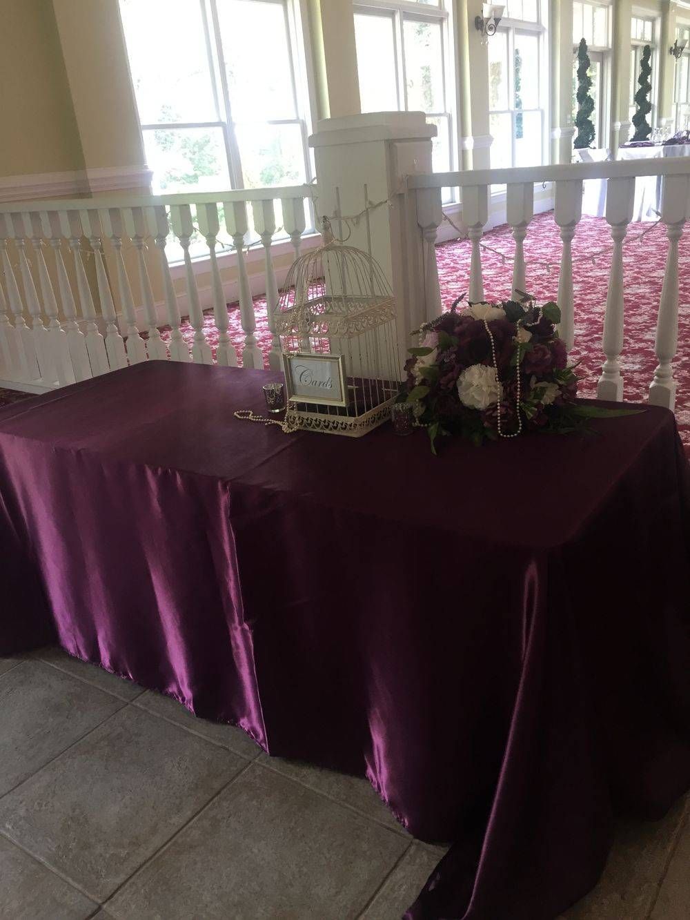 A table with a purple table cloth and flowers on it