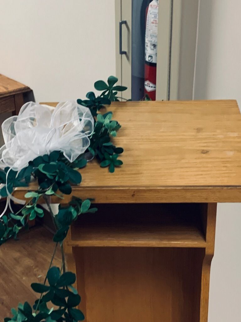 A wooden table with a white flower on top of it