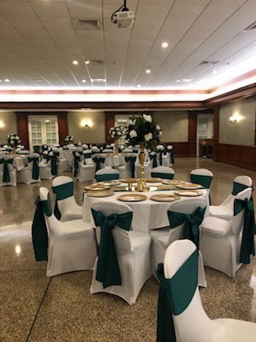 A large room with tables and chairs set up for a wedding reception.