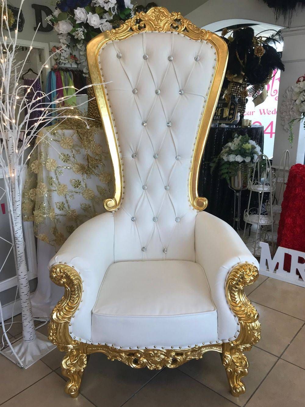 A white and gold chair is sitting in a room.