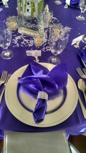 A purple napkin is on a plate on a table.