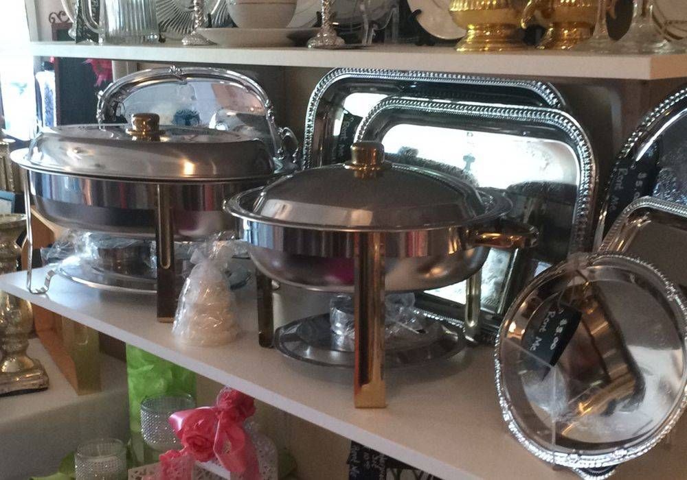 A shelf filled with stainless steel pots and pans