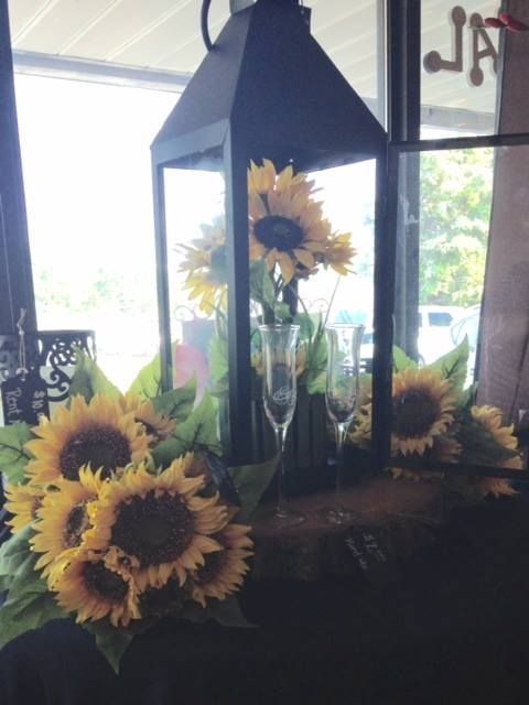 A black lantern with sunflowers inside of it