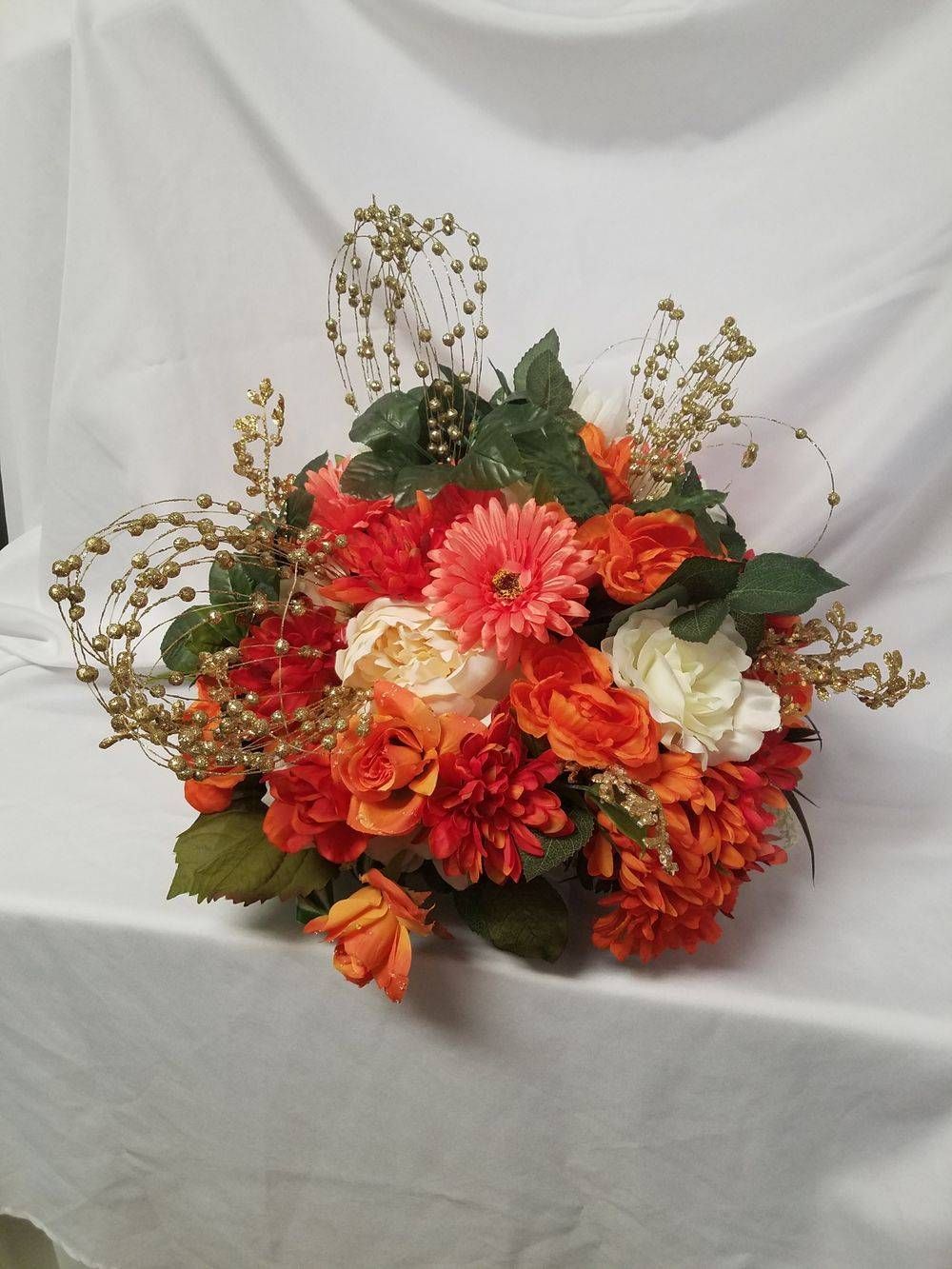 A bouquet of orange and white flowers is sitting on a table.