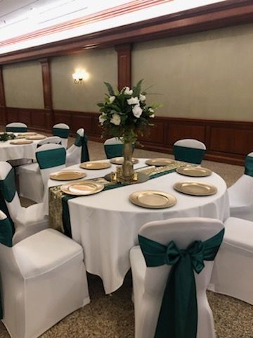 A room with tables and chairs set up for a wedding reception.