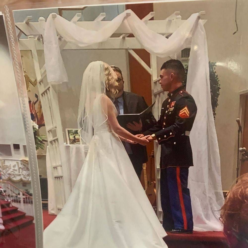A bride and groom are holding hands during their wedding ceremony