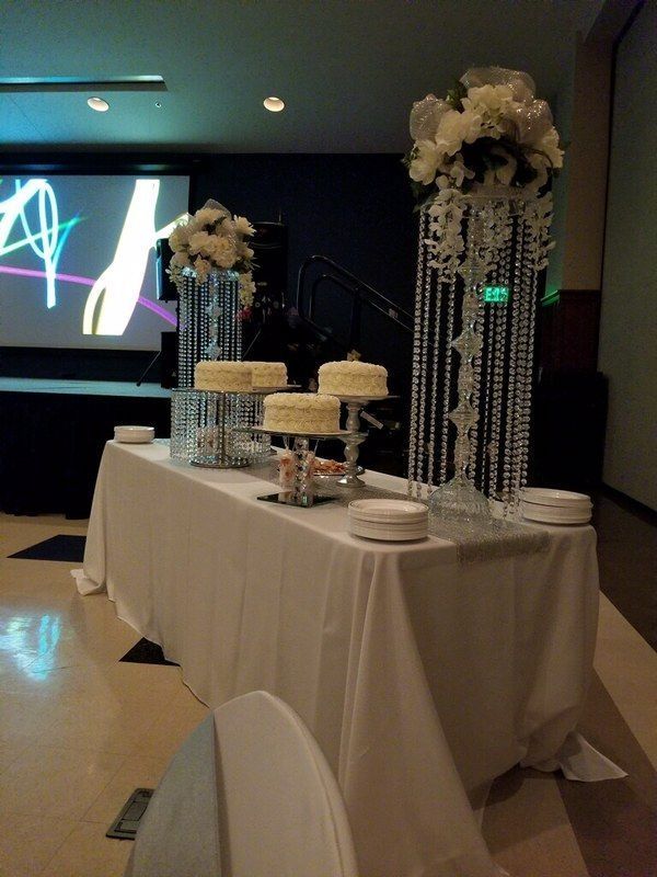 A table with three cakes and flowers on it