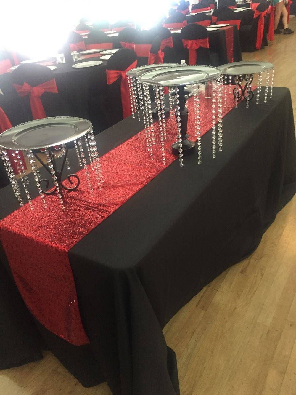 A table with a black table cloth and a red table runner