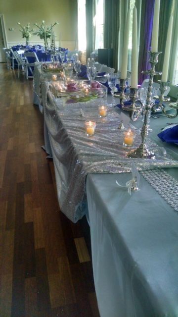 A long table with candles and plates on it in a room.