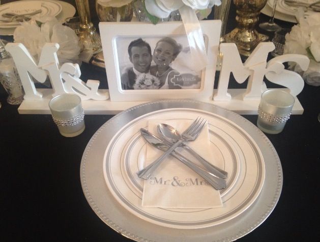 A picture of a bride and groom is on a table with plates and silverware