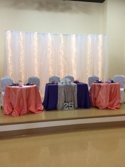 A room with tables and chairs set up for a wedding reception.
