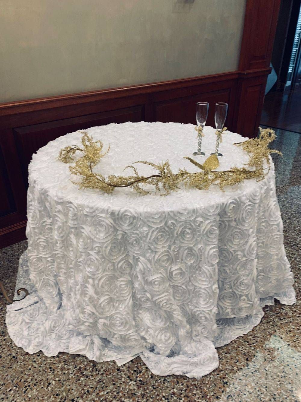A table with a white tablecloth and two glasses on it