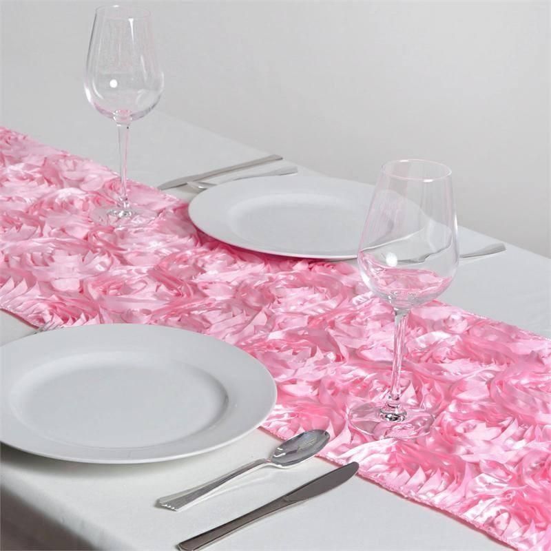 A table with plates glasses and a pink table runner
