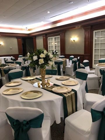 A large room with tables and chairs set up for a wedding reception.