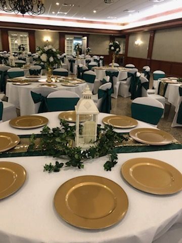 A large room with tables and chairs set up for a wedding reception.