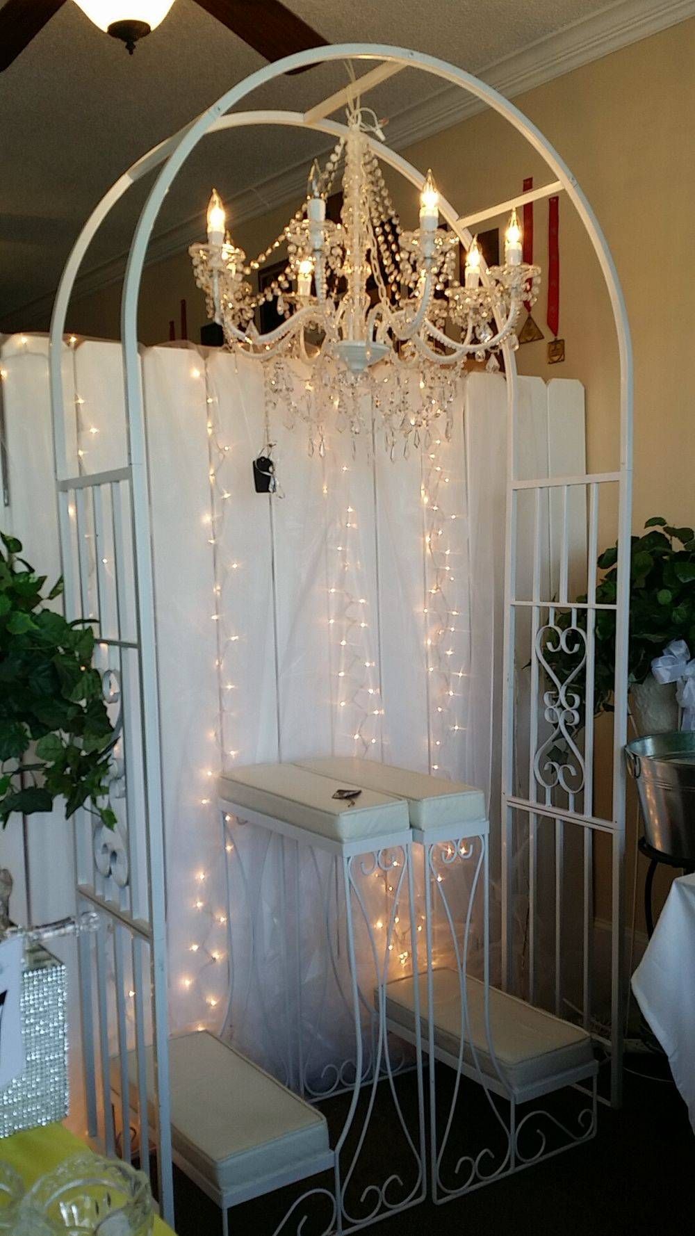 A white arch with a chandelier hanging from it