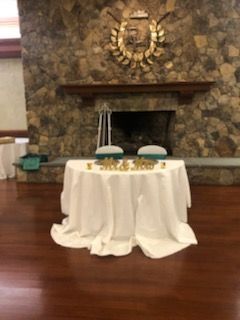 A table with a white tablecloth is in front of a fireplace.