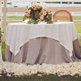 A table with a white table cloth and flowers on it.