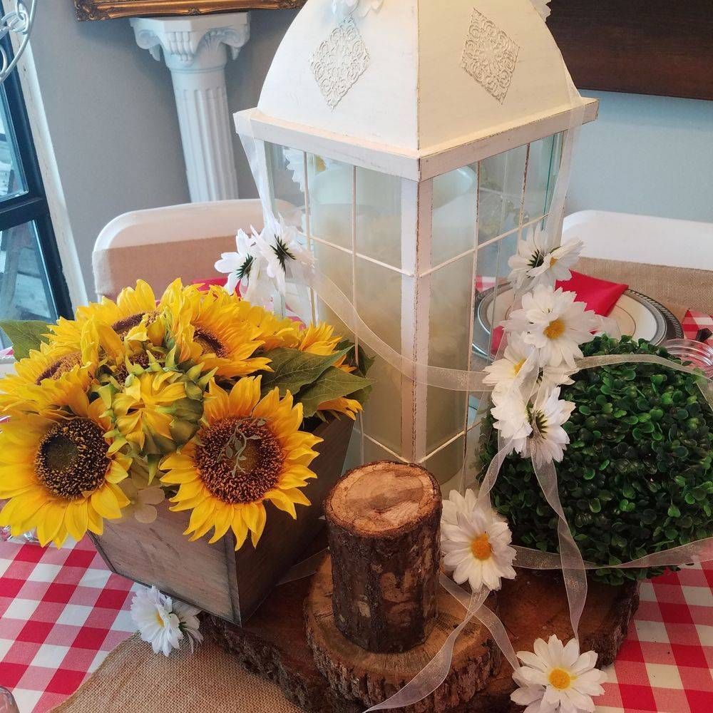 A table with a lantern and sunflowers on it