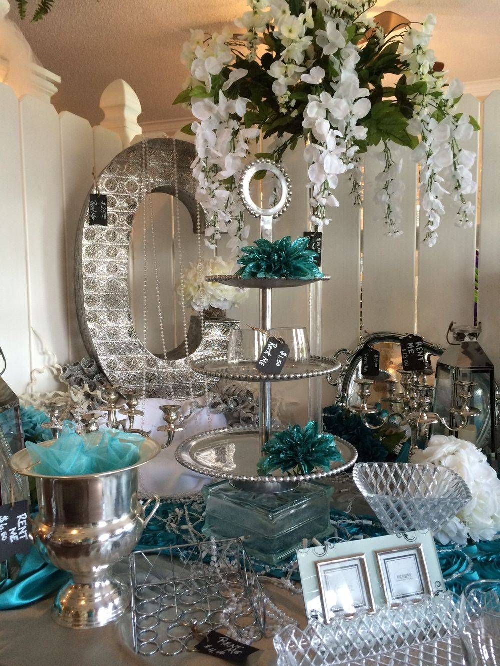 A table with a mirror , vases , clocks and flowers on it