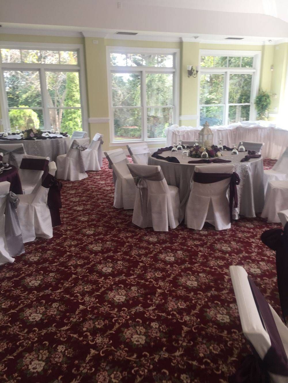 A room with tables and chairs set up for a wedding reception.
