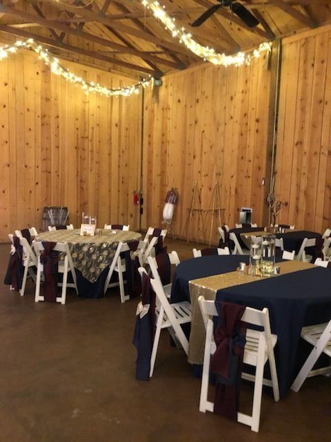 A room with tables and chairs set up for a wedding reception