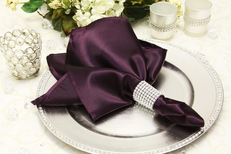 A purple napkin is sitting on top of a silver plate.